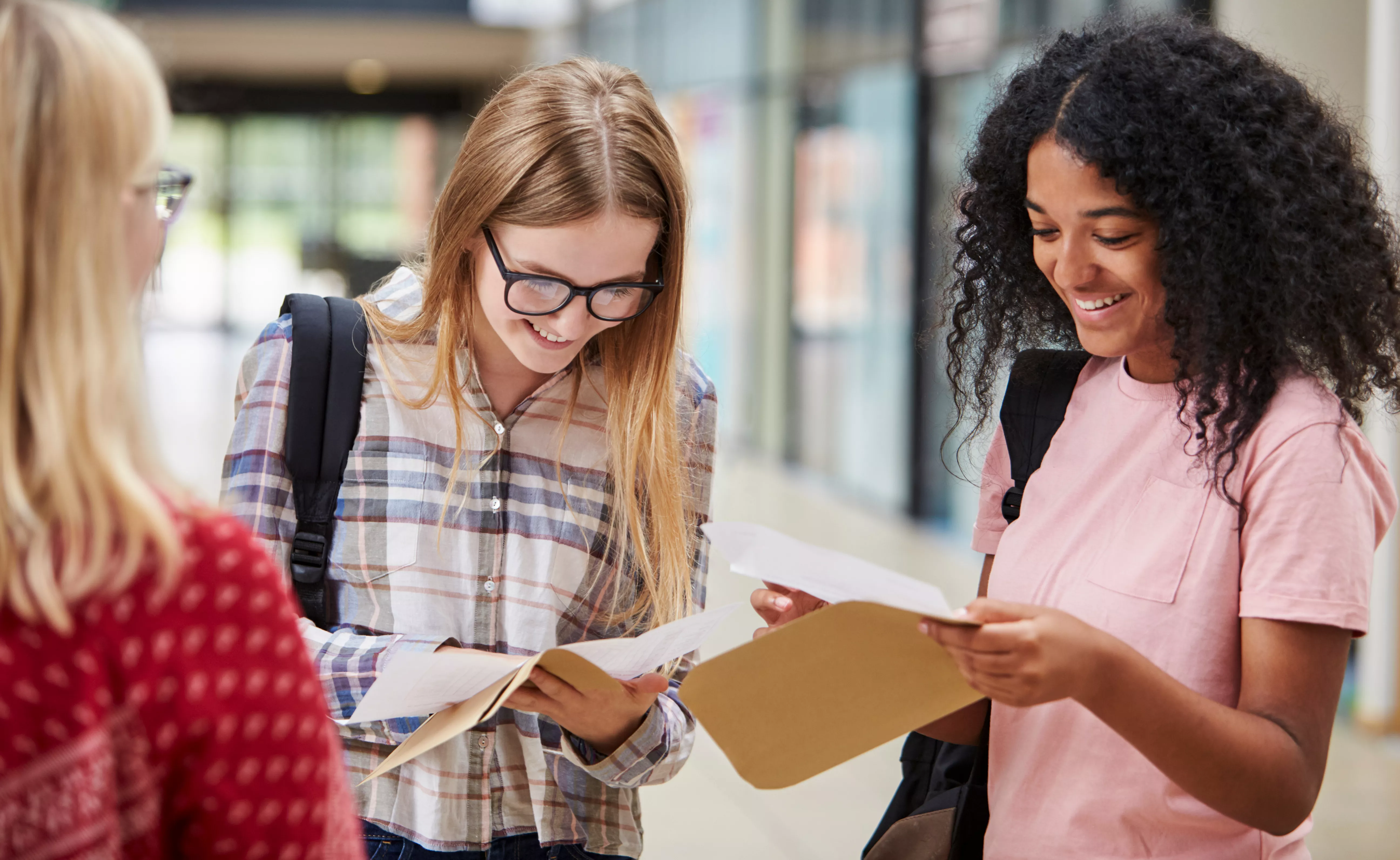 Image of three students smiling as they open exam results