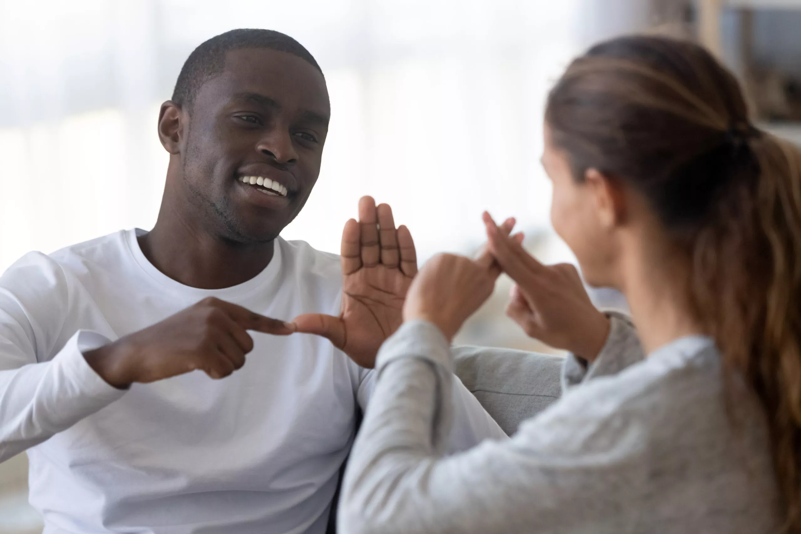 Image of two people talking to each other using sign language